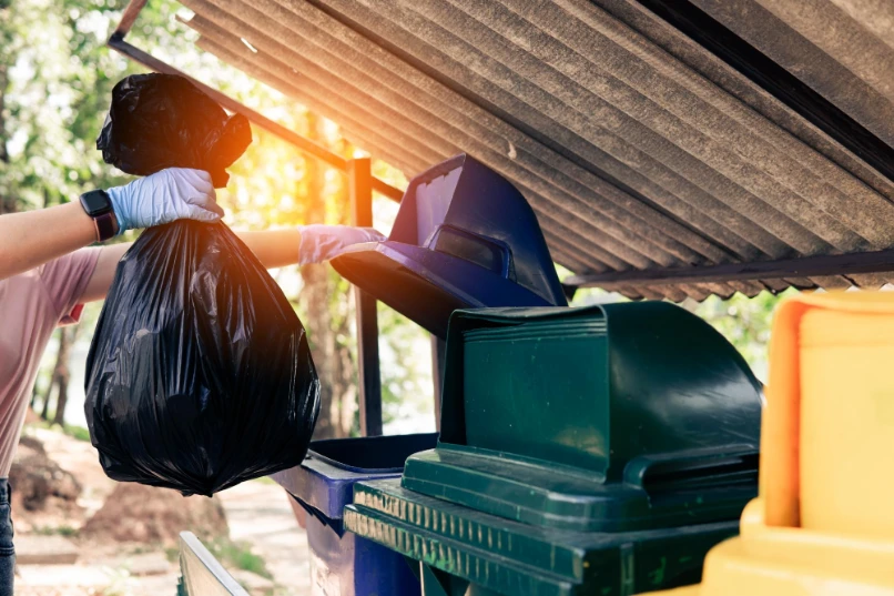 a woman holding plastic garbage clean dispose waste properly