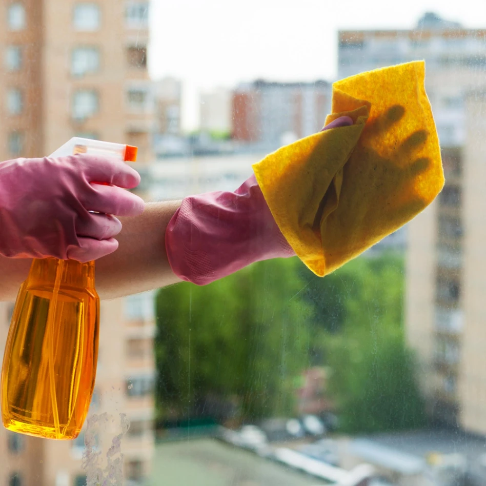 A cleaning person is cleaning a window with detergent in Denver, Colorado