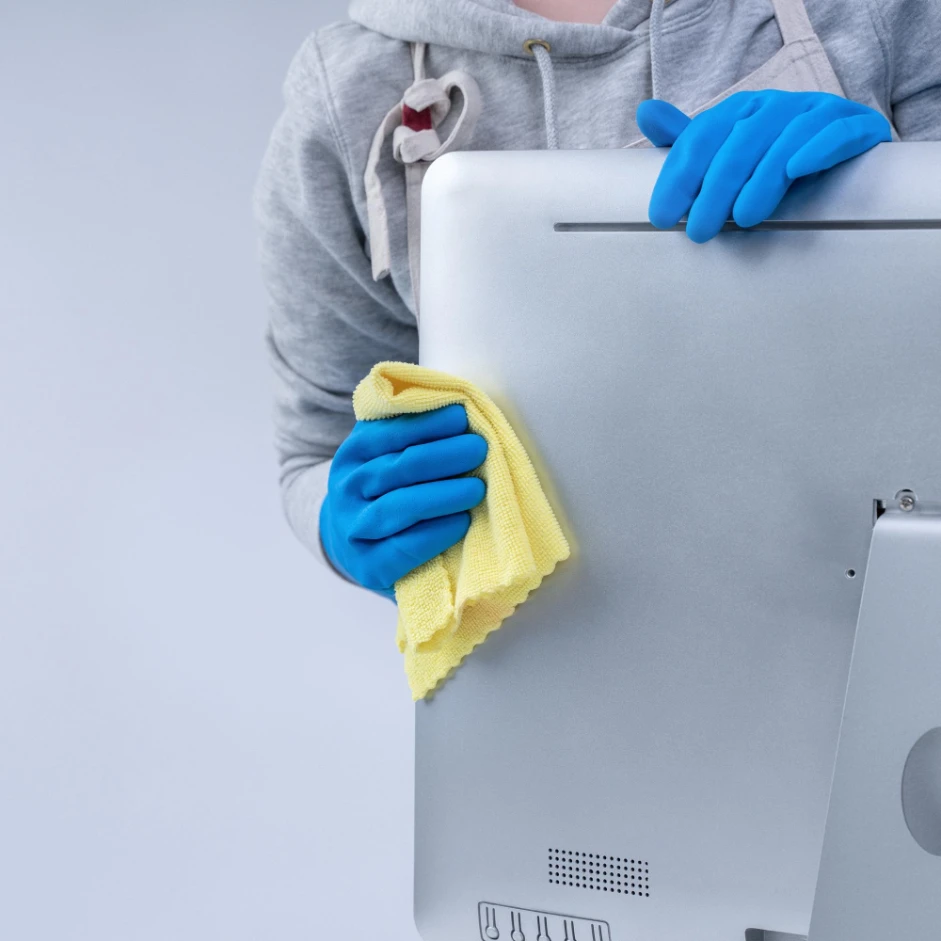 young woman housekeeper apron is cleaning silver computer surface