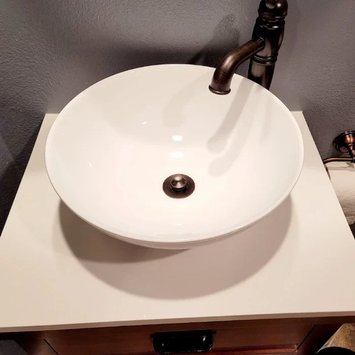 A white bathroom sink on a white counter.