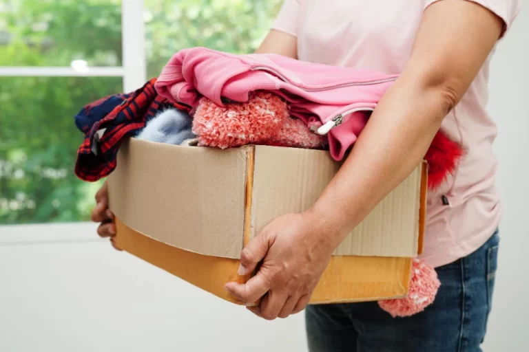 A close-up photo of a cleaning lady picking up dirty clothes in and around Denver.