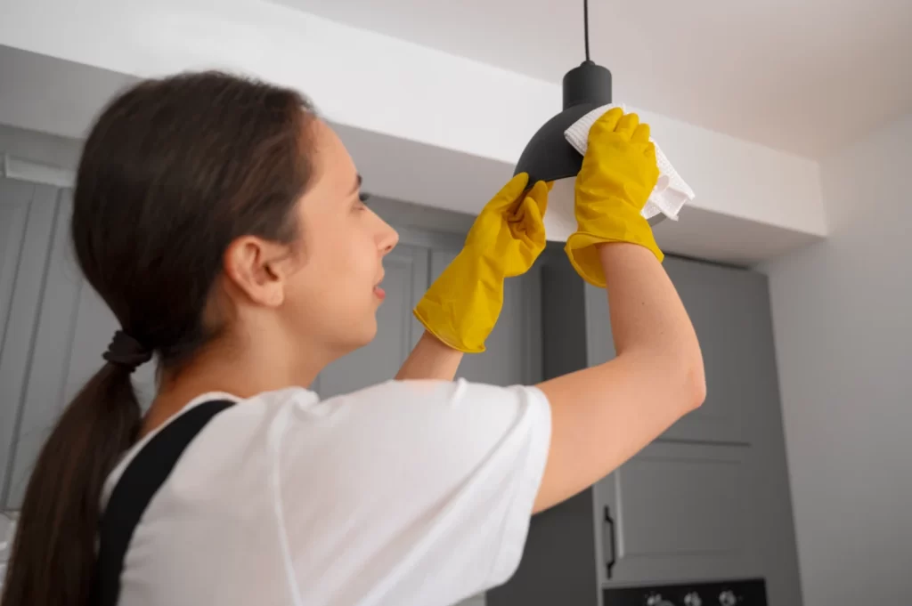 Medium shot of a woman cleaning a part of a lamp