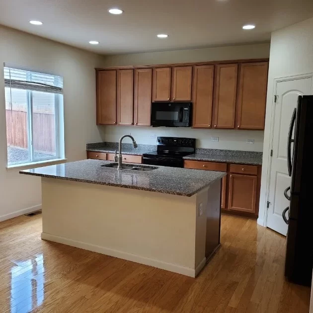 Modern kitchen featuring hardwood floors and stainless steel appliances.