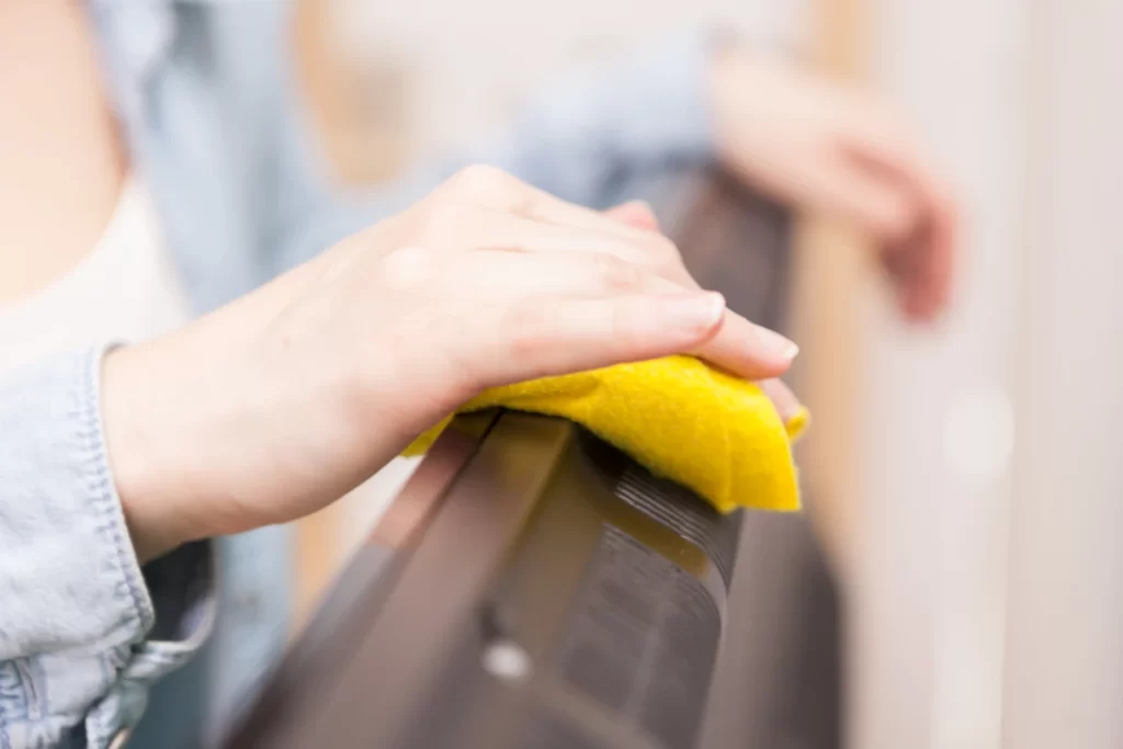 Housewife cleaning the dust of tv in living room